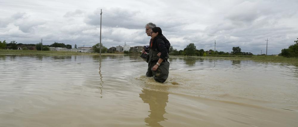 Italien, Lugo: Ein Paar geht auf einer überfluteten Straße. Nach einer monatelangen Trockenperiode in Norditalien regnete es in den vergangenen Wochen häufig und teils sehr intensiv.