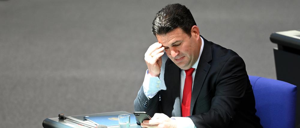 Hubertus Heil (SPD), Bundesminister für Arbeit und Soziales, sitzt während der Debatte im Plenum des Bundestags auf der Regierungsbank.