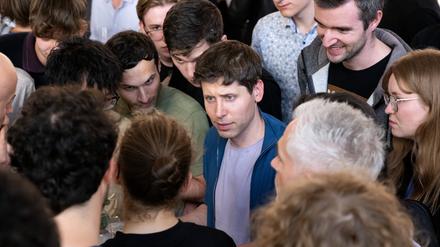 Sam Altman (M), Geschäftsführer (CEO) von OpenAI und Erfinder der KI-Software ChatGPT, unterhält sich an der Technische Universität München (TUM) nach einer Podiumsdiskussion mit den Zuhörern. 