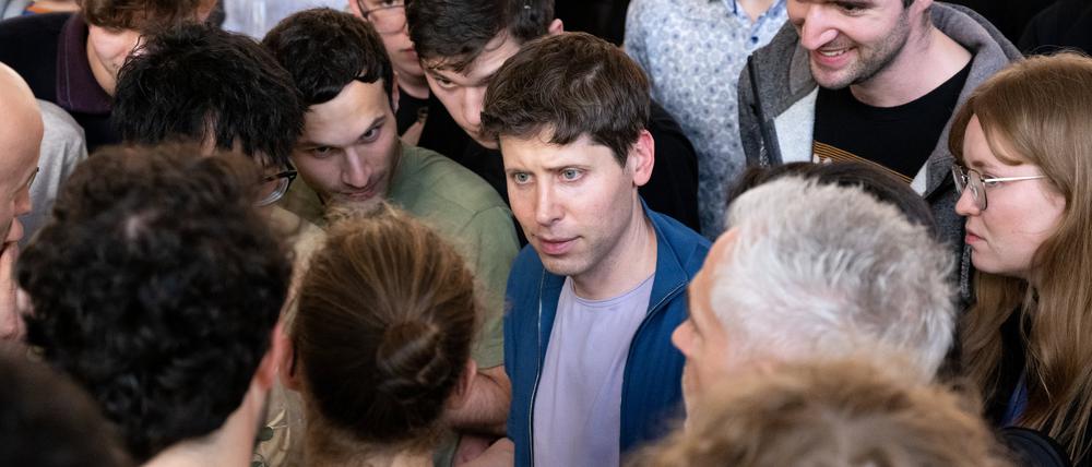 Sam Altman (M), Geschäftsführer (CEO) von OpenAI und Erfinder der KI-Software ChatGPT, unterhält sich an der Technische Universität München (TUM) nach einer Podiumsdiskussion mit den Zuhörern. 