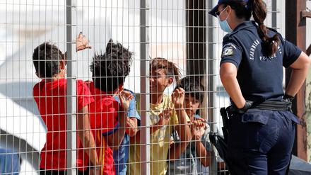 Eine Polizistin spricht in einem Lager auf der griechischen Insel Lesbos mit Flüchtlingskindern. 