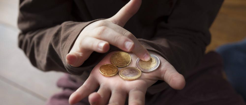 Ein Mädchen zählt Geld in ihrer Hand (Symbolbild). 