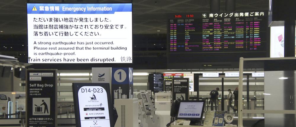 Eine elektronische Anzeigetafel am internationalen Flughafen Narita, östlich von Tokio, zeigt einen Hinweis auf das Erdbeben.
