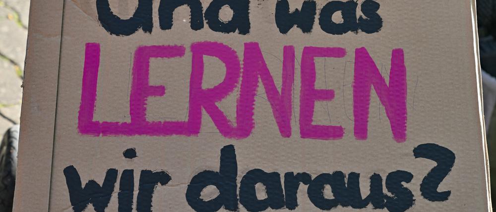 Ein Schild mit der Aufschrift «und was lernen wir daraus?» hält ein Kleinkind in seinem Wagen bei der Demonstration «Vielfalt statt Einfalt – Schule ohne Diskriminierung» vor dem Schulamt in Cottbus in seinen Händen.