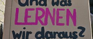 Ein Schild mit der Aufschrift «und was lernen wir daraus?» hält ein Kleinkind in seinem Wagen bei der Demonstration «Vielfalt statt Einfalt – Schule ohne Diskriminierung» vor dem Schulamt in Cottbus in seinen Händen.