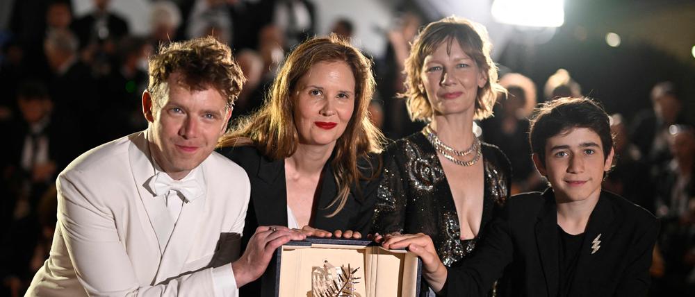 Palmengewinnerin Justine Triet (mitte) zwischen ihren Darstellern Antoine Reinartz (links) und Sandra Hüller und Milo Machado.