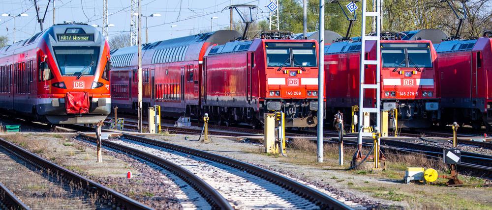 Personenzüge der Deutschen Bahn (DB) stehen auf Gleisen am Bahnhof.