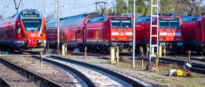 Personenzüge der Deutschen Bahn (DB) stehen auf Gleisen am Bahnhof. 