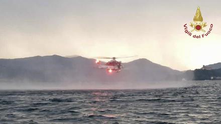 Dieses von der italienischen Feuerwehr veröffentlichten Bild zeigt einen Hubschrauber bei der Suche nach Vermissten, nachdem ein Touristen-Boot in einem Sturm auf dem italienischen Lago Maggiore gekentert ist.