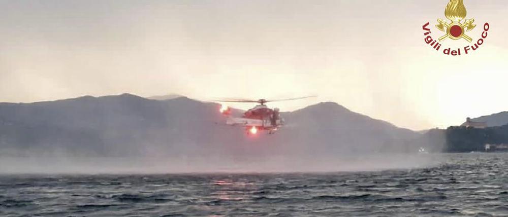 Dieses von der italienischen Feuerwehr veröffentlichten Bild zeigt einen Hubschrauber bei der Suche nach Vermissten, nachdem ein Touristen-Boot in einem Sturm auf dem italienischen Lago Maggiore gekentert ist.