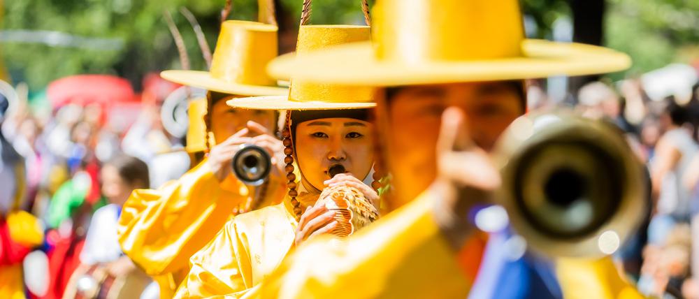 28.05.2023, Berlin: Darsteller einer koreanischen Gruppe treten beim Umzug des Karnevals der Kulturen in Berlin-Kreuzberg auf. Nach dreimaliger pandemiebedingter Absage findet das Straßenfest wieder statt und erreicht mit dem Umzug seinen Höhepunkt. Foto: Christoph Soeder/dpa +++ dpa-Bildfunk +++
