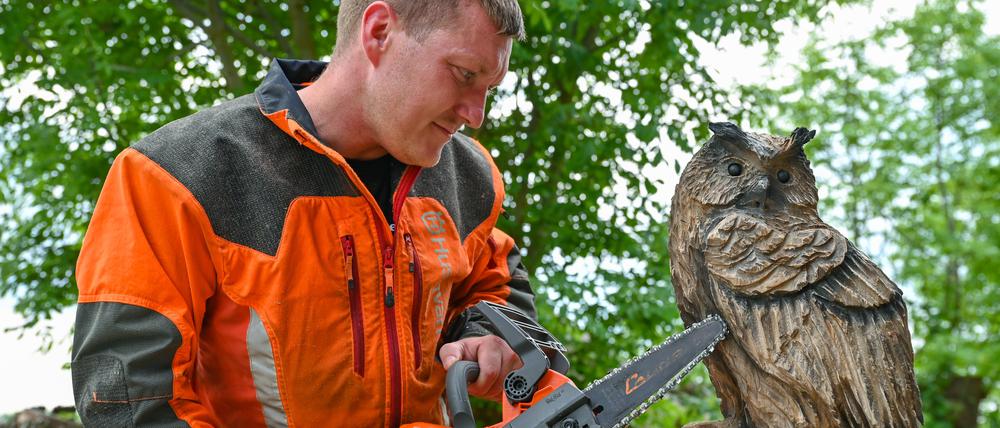 Christian Mücke, Kettensägen-Künstler, arbeitet an einem Uhu aus Holz. Speedcarving nennt sich die Kettensägenkunst, bei der in vorgegebener Zeit Skulpturen aus Holzstämmen entstehen.