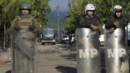 KFOR-Soldaten (vorne) und Kosovo-Polizisten bewachen ein städtisches Gebäude nach den gestrigen Zusammenstößen zwischen ethnischen Serben und Truppen der NATO-geführten KFOR-Friedenstruppe. 
