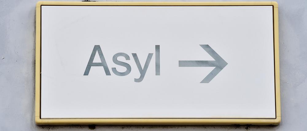 Ein Schild mit der Aufschrift „Asyl“ hängt in einer Landeserstaufnahme für Asylbewerber (LEA) an einer Wand.