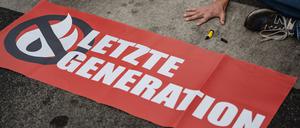 Ein Aktivist der Gruppe Letzte Generation, der seine Hand auf der Straße festgeklebt hat.