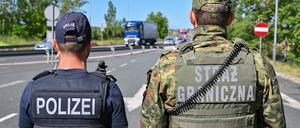 Ein deutscher Polizist und sein polnischer Kollegen stehen am Autobahngrenzübergang am Gemeinsamen Zentrum der Deutsch-Polnischen Polizei- und Zollzusammenarbeit. g
