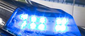 Eine Blaulicht leuchtet auf dem Dach eines Polizeiwagens. 