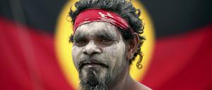 Rauchzeremonie. Stedman Sailor steht am Australia Day mit anderen Mitgliedern der indigenen Bevölkerung Australiens vor der Fahne der Aborigines.