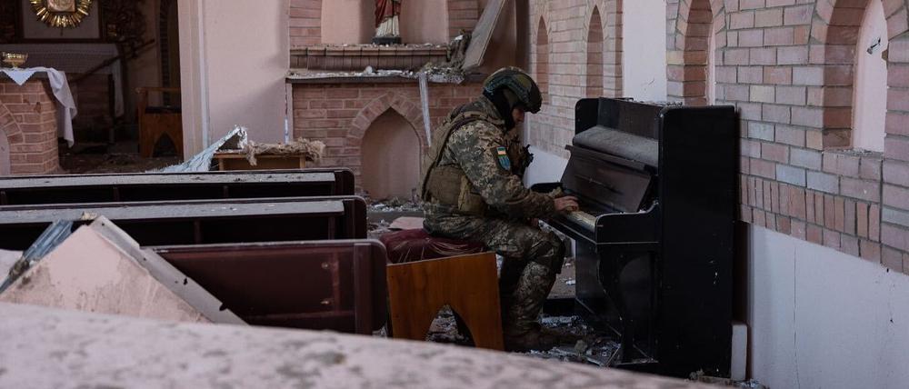 Paradies in der Hölle. Militärseelsorger Mark Kupchenenko spielt in einer zerstörten Kirche Klavier. Das Foto wurde am ersten Weihnachtstag aufgenommen.