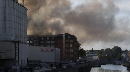 Dunkler Rauch steigt aus einem Betrieb in Neukölln. Dort brannte gepresstes Papier in einer Halle.