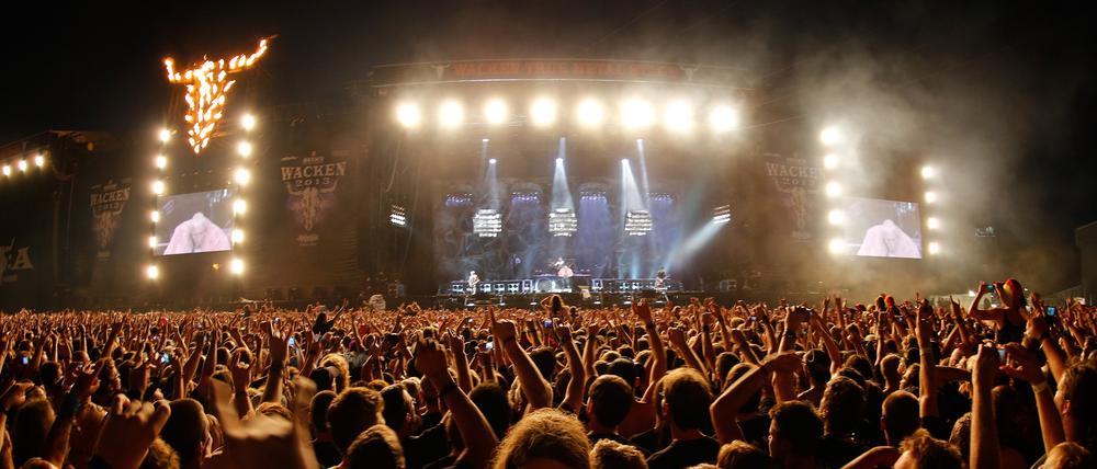 Eine Besucherin des Wacken Open-Air Festivals (WOA) lässt sich am 01.08.2013 im schleswig-holsteinischen Wacken beim Konzert der Band Rammstein auf den Händen der Zuschauer tragen.