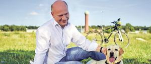 Der Regierende Bürgermeister Kai Wegner mit Hund – und Rad.