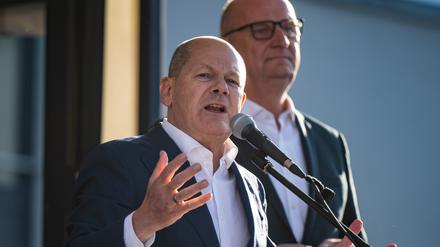 Bundeskanzler Olaf Scholz (l., SPD) spricht nach seinem Besuch bei der Landesvertreterversammlung auf dem Europafest vor der Stadthalle. Im Hintergrund steht Dietmar Woidke (SPD), Ministerpräsident von Brandenburg. 