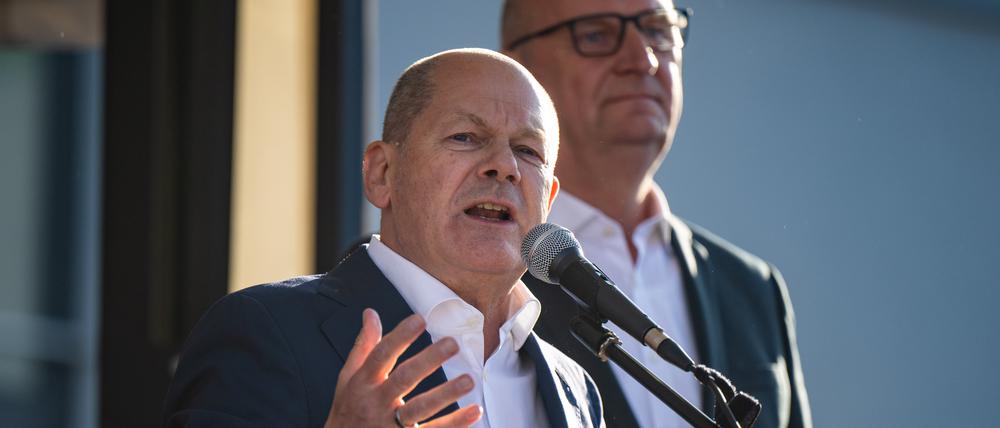 Bundeskanzler Olaf Scholz (l., SPD) spricht nach seinem Besuch bei der Landesvertreterversammlung auf dem Europafest vor der Stadthalle. Im Hintergrund steht Dietmar Woidke (SPD), Ministerpräsident von Brandenburg.