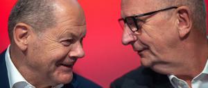 Bundeskanzler Olaf Scholz (l, SPD), und Dietmar Woidke (SPD), Ministerpräsident von Brandenburg, unterhalten sich während der Landesvertreterversammlung der SPD.