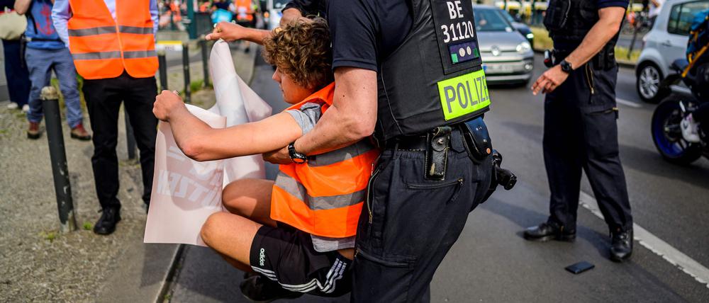 Eine Polizeikraft trägt einen Aktivisten der „Letzten Generation“ bei einem Einsatz weg (Symbolbild).