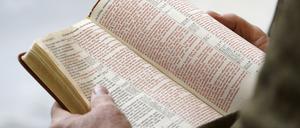 Eine Person hält eine Bibel in der Hand, während die Bibel im Kapitol von Utah vorgelesen wird. 