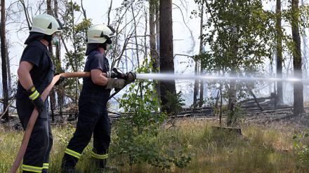 Zwei Feuerwehrmänner im Einsatz bei dem Waldbrandbrand bei Jüterbog.