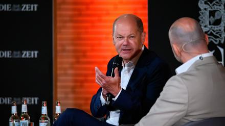 Bundeskanzler Olaf Scholz (SPD, l) spricht auf der Bühne im Audimax der Universität Hamburg mit Roman Pletter, Journalist bei der Zeit. 