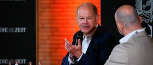 Bundeskanzler Olaf Scholz (SPD, l) spricht auf der Bühne im Audimax der Universität Hamburg mit Roman Pletter, Journalist bei der Zeit. 
