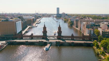 Ausflugsschiffe fahren an der Oberbaumbrücke auf der Spree in Richtung Innenstadt. (Drohnenaufnahme)