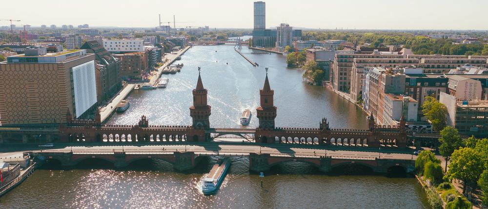 Ausflugsschiffe fahren an der Oberbaumbrücke auf der Spree in Richtung Innenstadt. (Drohnenaufnahme) 