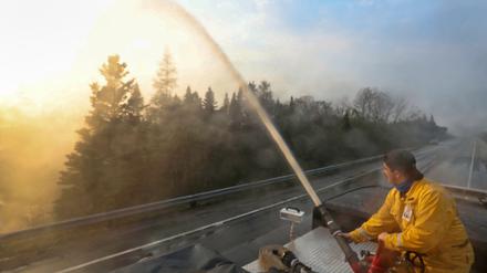 Eine Rettungskraft versucht das Feuer zu löschen.