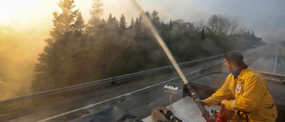 Eine Rettungskraft versucht das Feuer zu löschen.