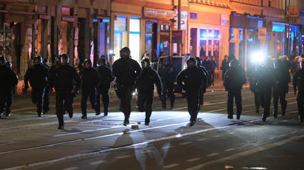 Polizisten rennen eine Straße entlang.