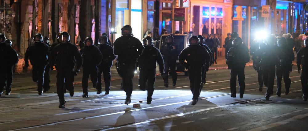 Polizisten rennen eine Straße entlang.