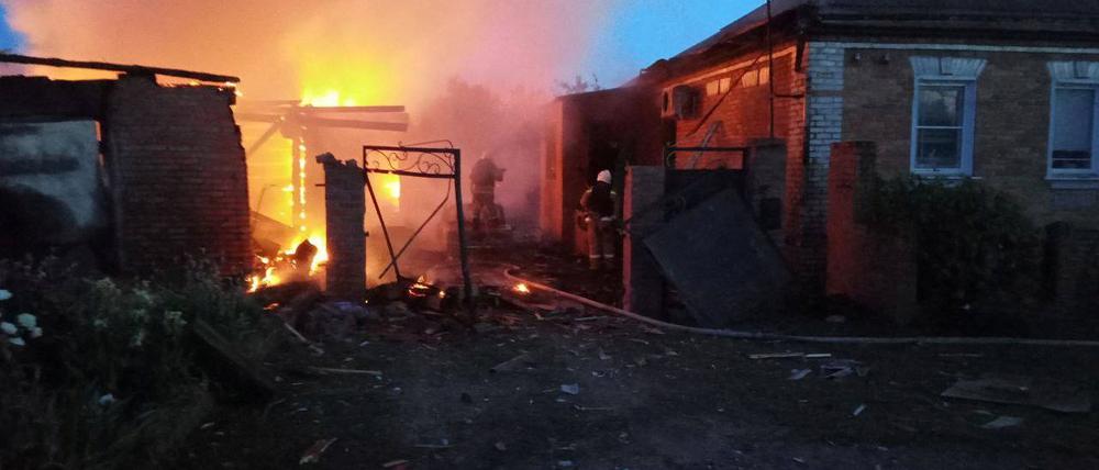 Feuerwehrleute versuchen am 2. Juni den Brand an einem Haus im Dorf Sobolevka in der Region Belgorod zu löschen.
