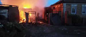 Feuerwehrleute versuchen am 2. Juni den Brand an einem Haus im Dorf Sobolevka in der Region Belgorod zu löschen.