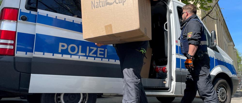 Ein Polizist trägt Kisten auf eine Polizeiwache.