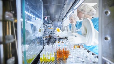 Chemical workers passing chemical bottles inside microbiological safety cabinet model released, Symbolfoto property released, CVF02391 