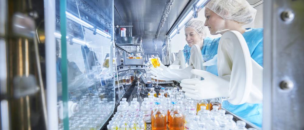Chemical workers passing chemical bottles inside microbiological safety cabinet model released, Symbolfoto property released, CVF02391 