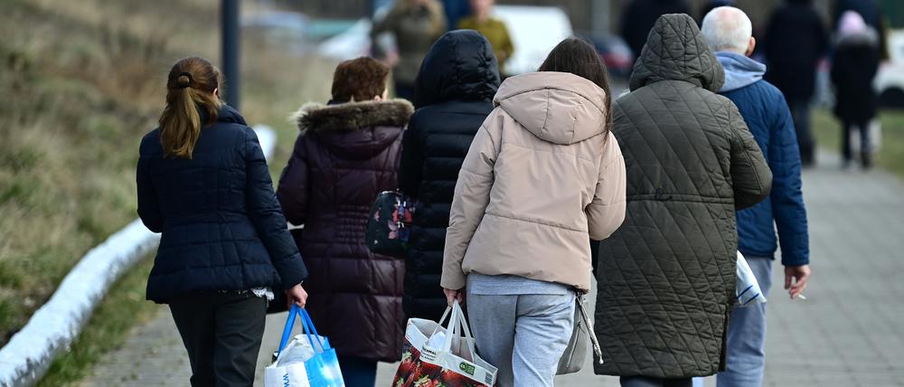 Ukrainische Flüchtlinge gehen nach ihrer Registrierung in der Orangerie der Biosphäre Potsdam zur Straße. Das Land will die Kommunen entlasten und ihnen deutlich weniger Flüchtlinge zuteilen. 