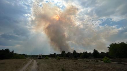 dpatopbilder - 07.06.2023, Brandenburg, Jüterbog: Rauch steigt aus einem Waldstück nahe Jüterbog in die Höhe und verdeckt die Sonne. Starker Wind hat den vor einer Woche ausgebrochenen Waldbrand bei Jüterbog nach Angaben der Einsatzleitung wieder angefacht. Geplant ist, den Brand auf dem ehemaligen Truppenübungsplatz wieder aus der Luft zu bekämpfen. Foto: Sven Kaeuler/TNN/dpa +++ dpa-Bildfunk +++