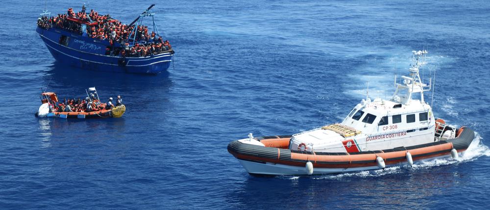 Die italienische Küstenwache (rechts) beobachtet vor der Küste Siziliens die Rettungsaktion der Organisation „Ärzte ohne Grenzen“, die Migranten und Flüchtlinge im Mittelmeer von einem Boot in Seenot retten. 