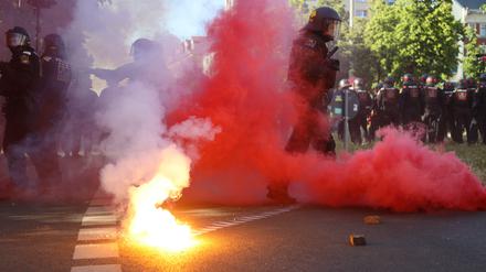 Bei Protesten gegen das Urteil im Prozess gegen Lina E. in Leipzig stehen Polizisten in roten Qualm, nachdem linke Demonstranten Pyrotechnik gezündet und geworfen hatten.