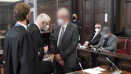Die beiden angeklagten Ärzte (hinten r und vorne 3.v.l) warten mit ihren Rechtsanwälten Leon Kruse (l), Ulrich Steffen (2.v.l) sowie Lorenz von Geyso (2.v.r) im Sitzungssaal des Landgerichts im Strafjustizgebäude auf den Beginn des Prozesses wegen des Todes eines Kindes nach einer Operation. 